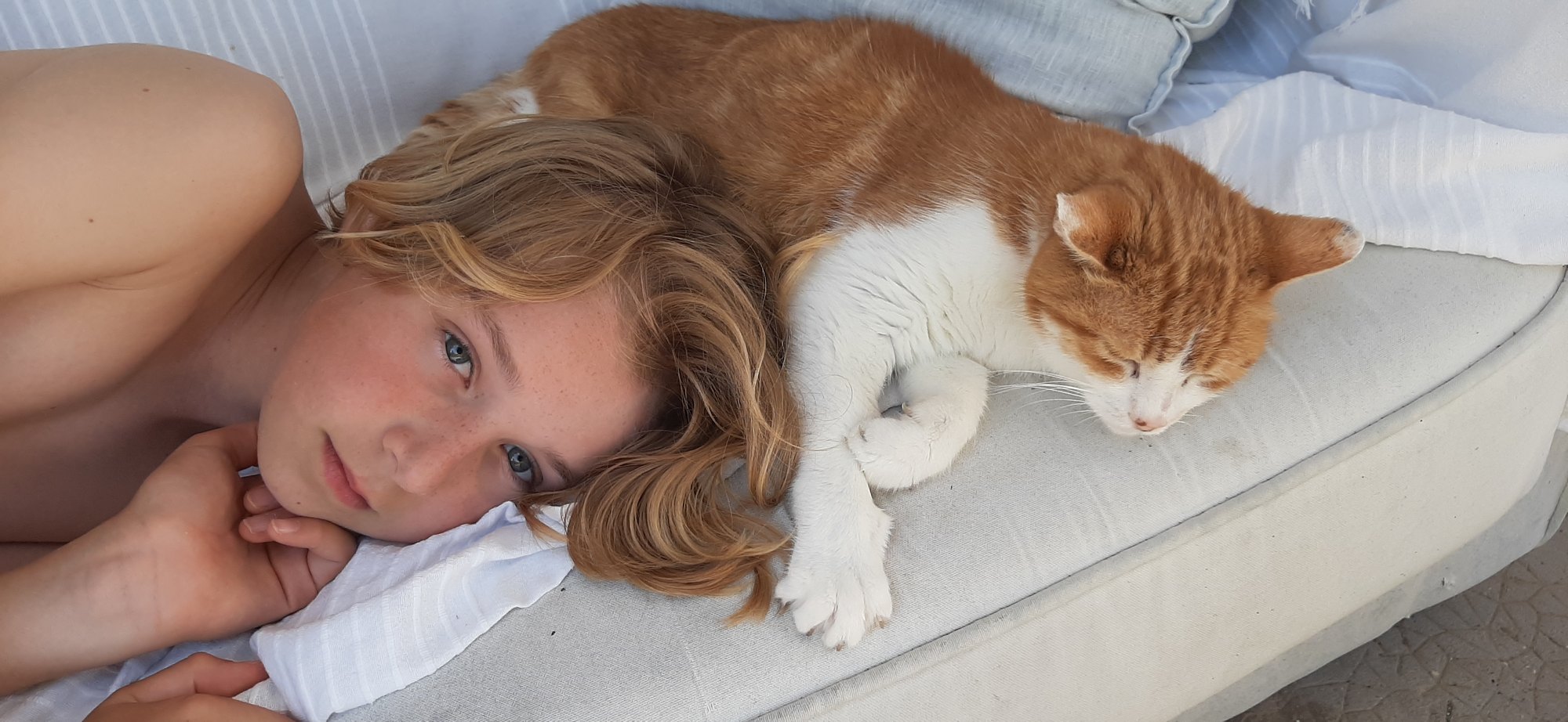 Jeune personne allongée auprès de son chat roux et blanc